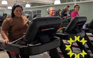 People smiling and walking on treadmills at the Create Healthy Wellness Center.